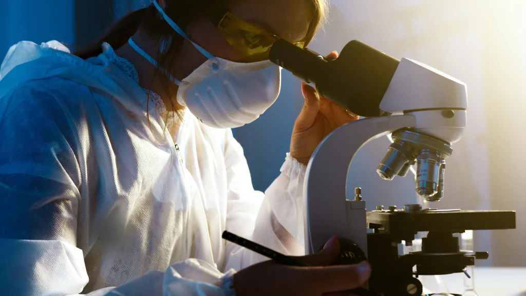 student using microscope in laboratory
